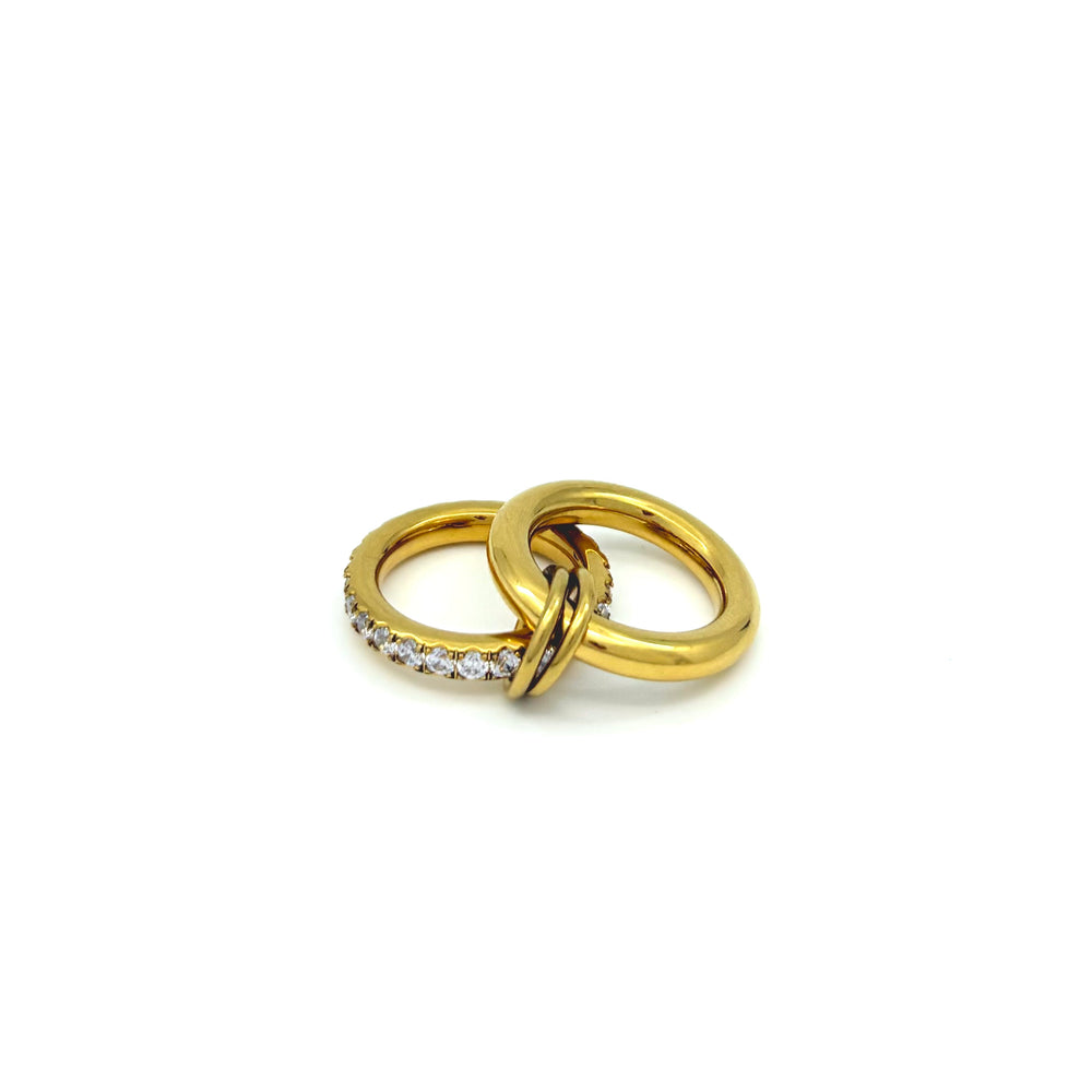 Anello in acciaio inox e Ottone, dorato composto da due fedi spesse, tenute insieme da due anellini dorati, tono su tono.Nichel nei termini di legge. Si può indossare anche a più dita insieme. Foto anello steso 